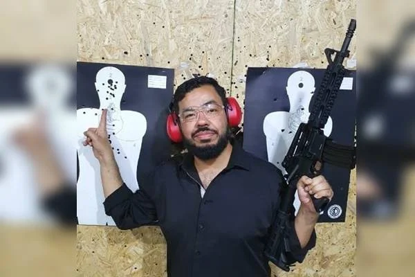 Deputado Loester Trutis segurando arma e apontando para alvo de tiro - Metrópoles
