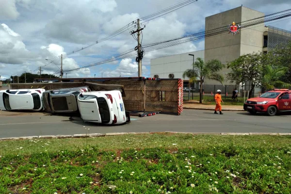 Caminhão tombado e carros na pista. Homem anda no local