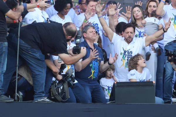 Tarcísio de Freitas ajoelhado, em oração, na Marcha para Jesus