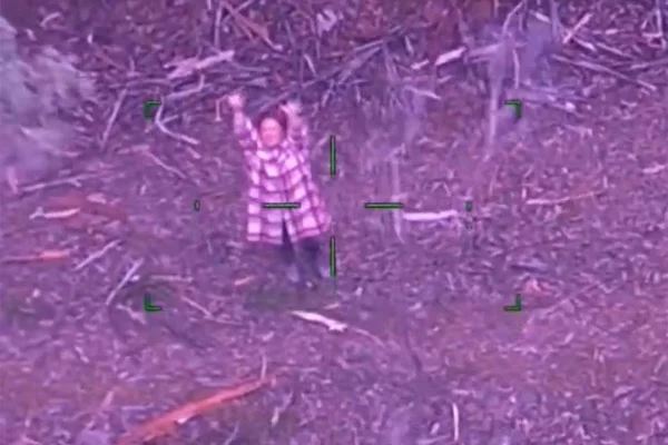 Foto colorida do momento em que mulher acena para o helicóptero de socorristas - Metrópoles