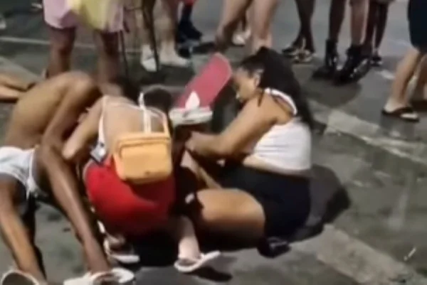 Imagem colorida de foliões desmaiados após PM usar spray de pimenta e bombas para dispersar bloco de carnaval - Metrópoles