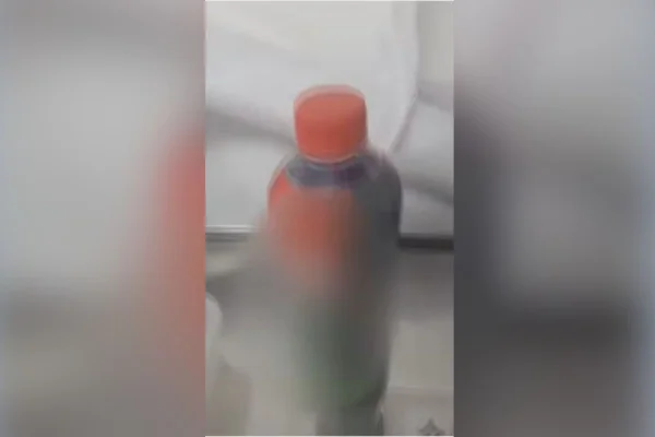Foto colorida de garrafa de energético onde a soda caustica estava armazenada - Metrópoles