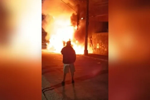 Imagem colorida mostra caminhão pegando fogo e homem vendo as chamas. Um outro morreu carbonizado - Metrópoles