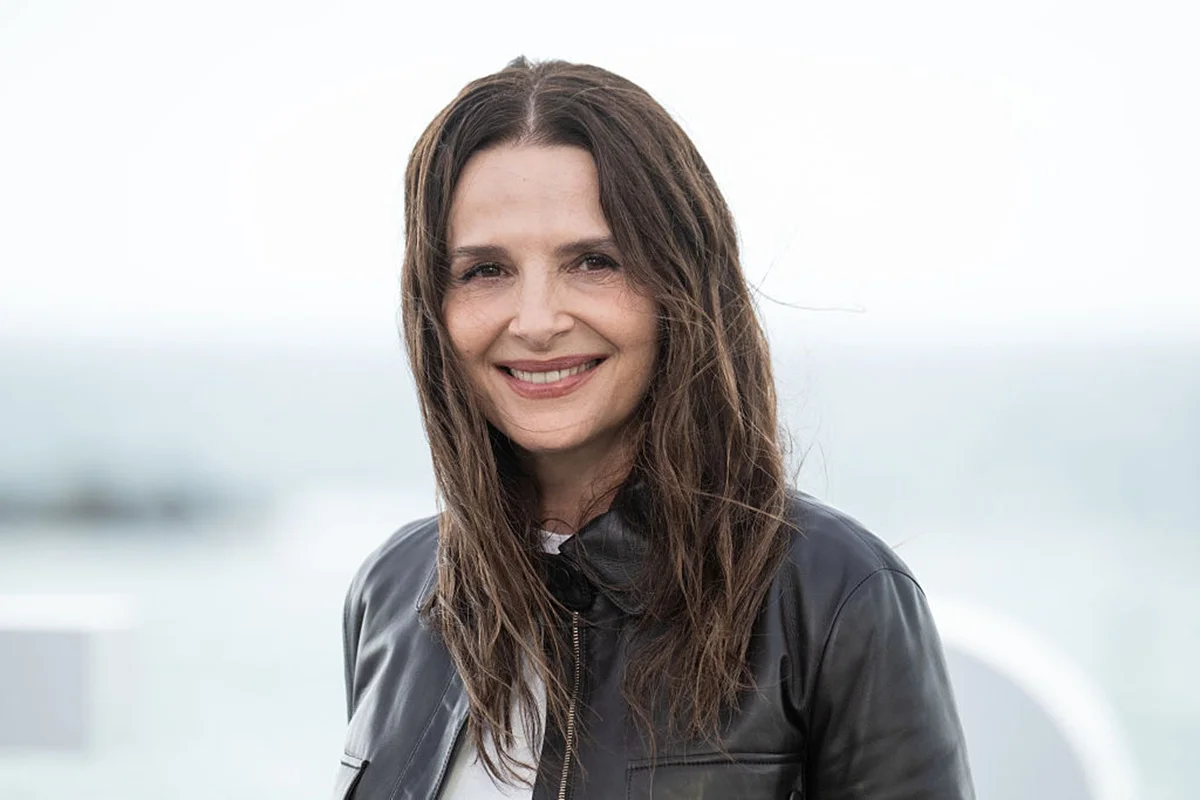 foto colorida de Juliette Binoche, mulher branca de cabelos médios castanhos sorrindo - metrópoles