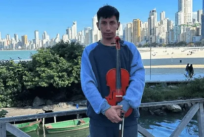 Fotografia colorida de violonista venezuelano que toca músicas clássicas nas ruas de Balneário Camboriú