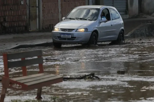 Imagem colorida de um carro na estrada alagada - Metrópoles