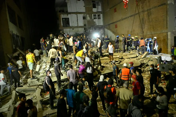 Pessoas e equipes de resgate buscam vítimas entre os escombros de um prédio de sete andares que desabou na Plaza Bolívar, em Pereira, Colômbia, após um terremoto de magnitude 7,4 atingir o país