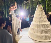 Giulia Be subiu nos ombros do marido, Conor Kennedy, para cortar o bolo gigante