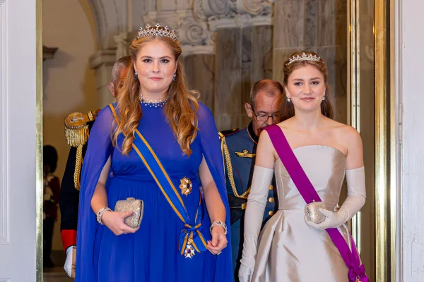 Foto colorida de duas mulheres caminhando. Elas usam tiaras e uma faixa no tronco - Metrópoles
