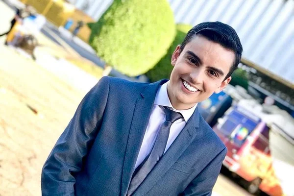 Dudu Camargo de terno e sorrindo - Metrópoles