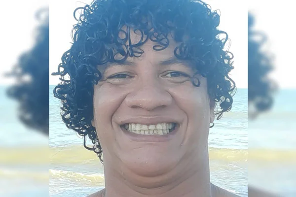 Foto colorida de homem branco com cabelo enrolado