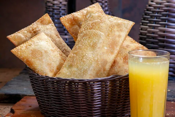 Foto colorida de vários pastéis com suco - Metrópoles