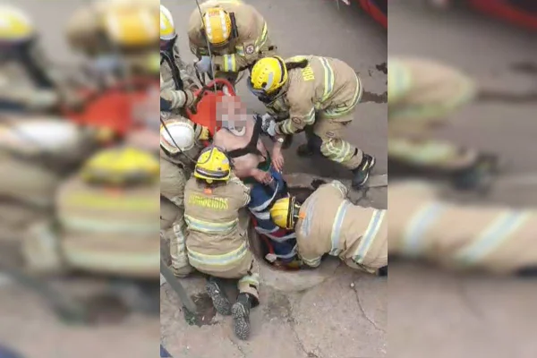 Foto colorida de bombeiros fazendo resgate de idoso