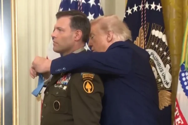 Imagem colorida mostra Trump tentando colocar medalha em militar - Metrópoles