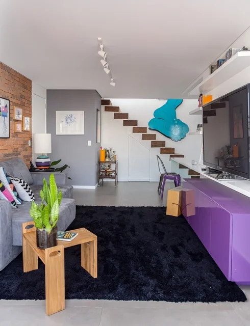 O móvel roxo abaixo da televisão também ajuda a dar o ar moderninho ao imóvel O móvel roxo abaixo da televisão também ajuda a dar o ar moderninho ao imóvel