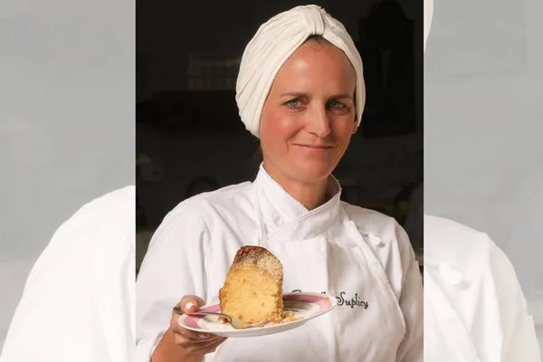 A confeiteira paulista Isabella Suplicy mostra pedaço de bolo sob prato rosa e branco - Metrópoles