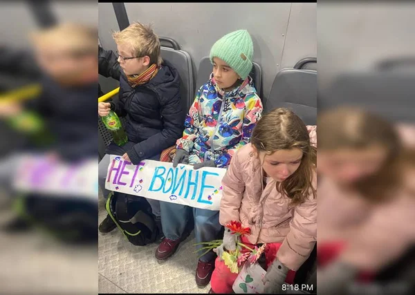 Crianças foram presas em protesto antiguerra. Elas aparecem sentadas e segurando um cartaz que diz "Não a guerra" - Metrópoles