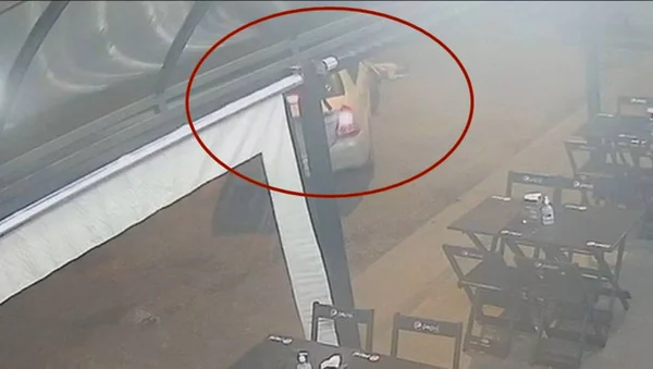Imagem colorida de uma pessoa deitada no chão próxima a um carro - Metrópoles