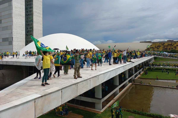 Imagem colorida de bolsonaristas em cima do Congresso Nacional
