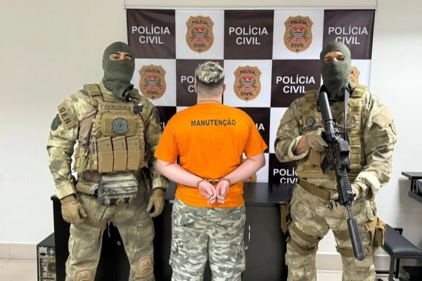 Imagem colorida mostra policiais com homem preso por integrar quadrilha que vendia pornografia infantil - Metrópoles