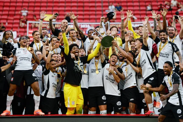 Foto colorida dos jogadores do Corinthians levantando a taça da Supercopa do Brasil - Metrópoles