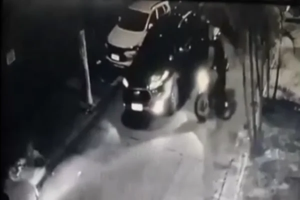 Imagem em preto em branco de motociclista atirando em motorista. Metrópoles