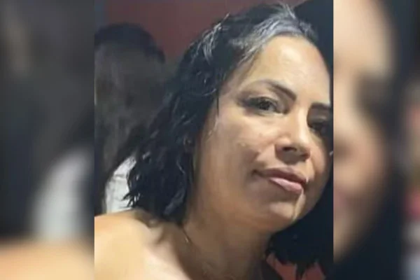 imagem colorida mostra mulher com cabelo preto e curto. ela usa batom rosa e tem sorriso discreto