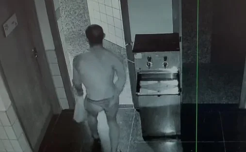 Homem de calcinha segurando sacola