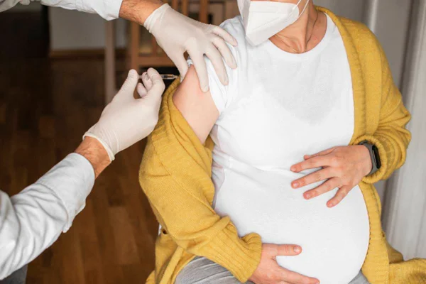Imagem colorida de mulher tomando vacina durante gestação