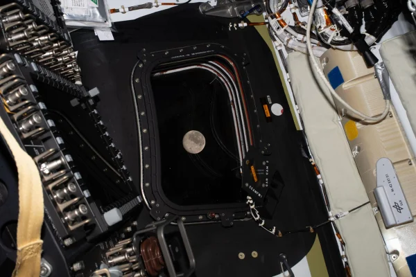 Imagem mostra a lua através da janela da espaçonave Orion. Metrópoles
