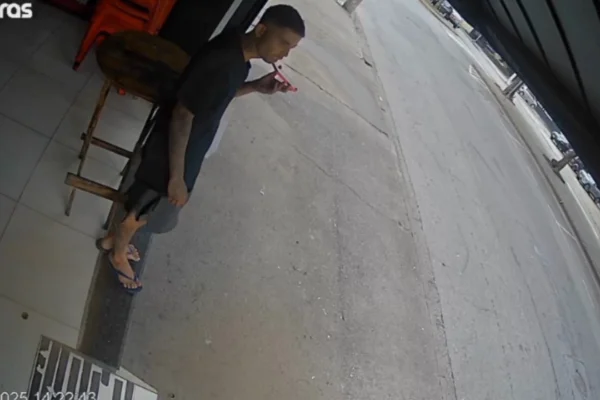 Imagem colorida de homem em porta de estabelecimento antes de desaparecer. Metrópoles