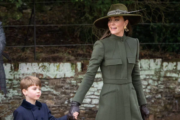 Foto colorida de menino branco e loiro de mãos dadas com mulher branca vestida com roupas na cor verde-militar - Metrópoles