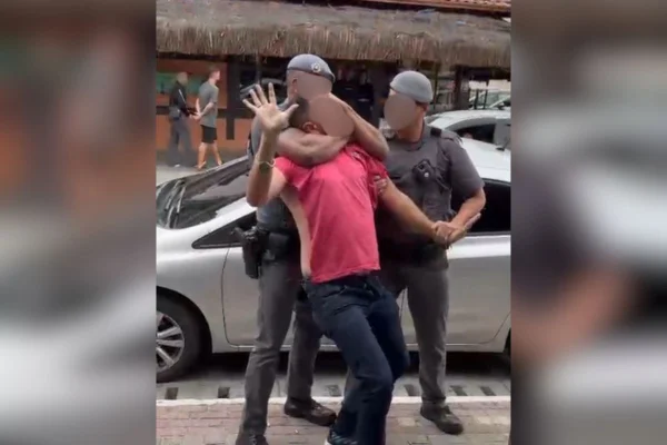 Captura de tela colorida, com blur, de vídeo que mostra abordagem de PMs a homem em Ubatuba. - Metrópoles
