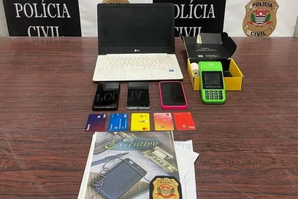 Imagem colorida mostra celulares, computador e outros materiais apreendidos. Metrópoles