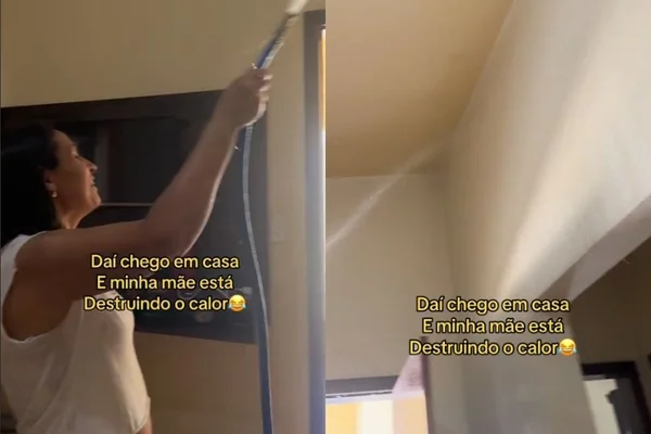 Foto colorida de uma mulher segurando uma mangueira e molhando a casa - Metrópoles