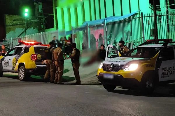 Foto colorida de carros da polícia em frente a igreja onde jovem foi morto - Metrópoles