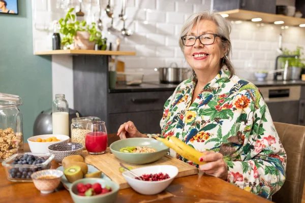 Foto colorida de mulher sentada e comendo - Metrópoles