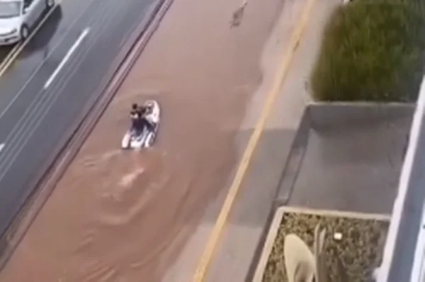 Imagem colorida mostra trecho de vídeo em que homem pilota jet-ski em rua alagada de goiânia - Metrópoles