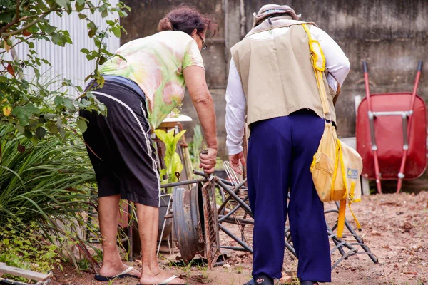 Foto colorida de agente revistando casa para achar focos de dengue