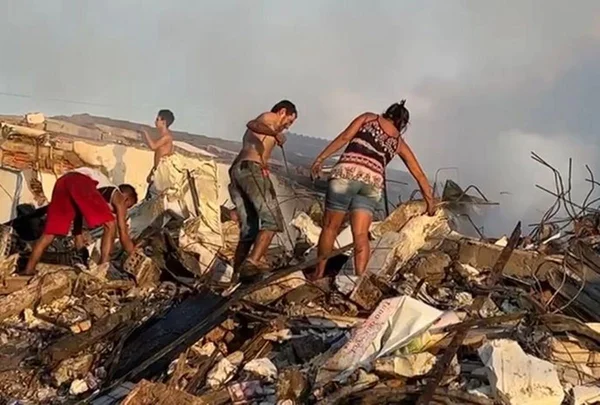 Moradores buscam alimentos em supermercado demolido após incêndio