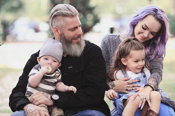 Foto colorida de família com pais e dois filhos - Metrópoles