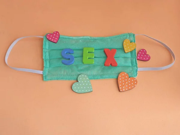 Máscara com letras formando a palavra sex