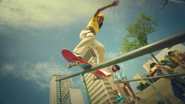 A jovem skatista profissional Rayssa Leal aparece fazendo manobra em skate num corrimão em nova campanha do Banco do Brasil, próxima de outros jovens - Metrópoles