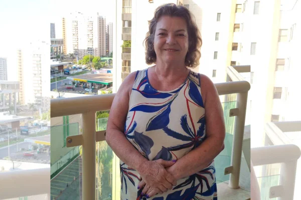 Mulher sorri em varanda de apartamento - Metrópoles