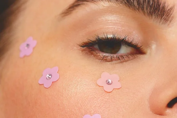 Rosto de mulher com adesivos em formato de flores - Metrópoles