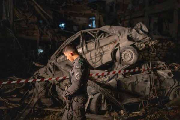 Imagem colorida de soldado com carro destruído em ataque ao fundo
