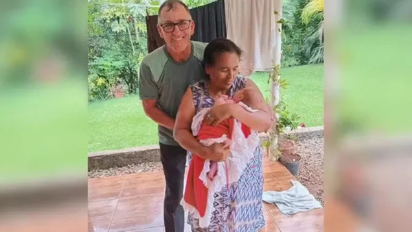 casal abraçado sorrindo com criança no colo