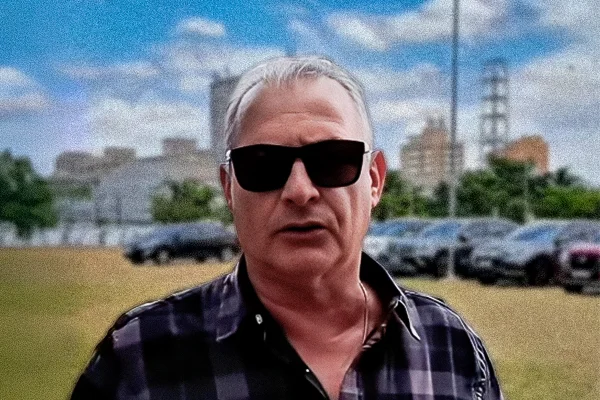 Arte mostra subprefeito da Lapa, Coronel Telhada, em primeiro plano, e carros estacionados sobre gramado ao fundo