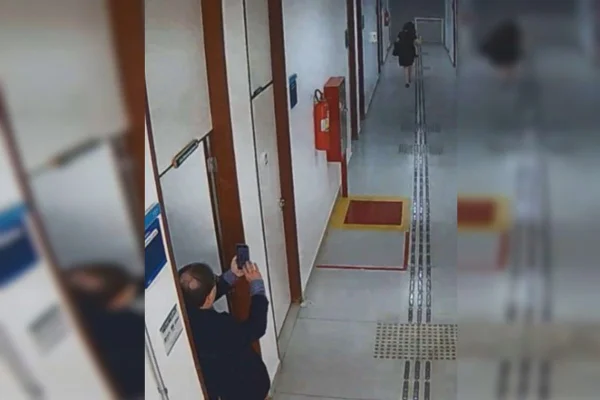 Homem filmando mulher em corredor