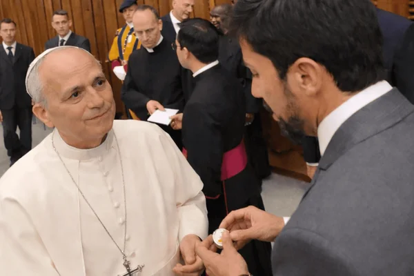 Imagem colorida de papa entregando rosário para amigo de padre Lancellotti - Metrópoles